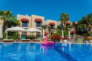 a pool at a resort with a pink flamingo in the middle at Bodrium Hotel & Spa in Bodrum City