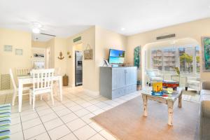 a living room with a table and a dining room at Funshine Pointe Capri in St Pete Beach