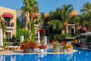 a pool at a hotel with palm trees and plants at Bodrium Hotel & Spa in Bodrum City +101 photos