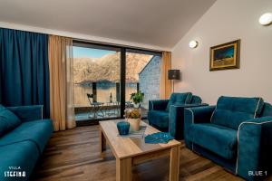 a living room with blue couches and a table at Villa Stefina in Kotor
