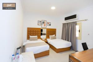 a hotel room with two beds and a desk at Almanzel Sheikh Zayed in 6th Of October
