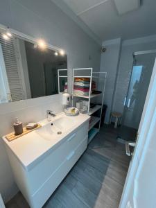 ein Badezimmer mit einem weißen Waschbecken und einem Spiegel in der Unterkunft SUL MARE in Puerto de Santiago
