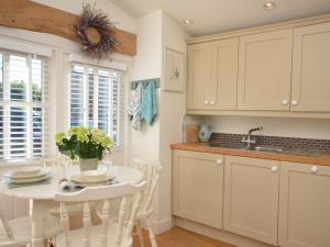 una cucina con armadi bianchi e tavolo bianco di 1 Bed in Bibury 29026 a Quenington