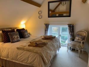 a bedroom with a bed and a mirror and a chair at 1 Bed in Bibury 29026 in Quenington