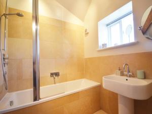 a bathroom with a tub and a sink and a shower at 1 Bed in Bibury 29026 in Quenington
