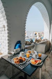 a table with breakfast foods and orange juice on it at Meandros Boutique & Spa Hotel - Adults Only in Kalamaki
