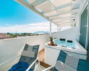 einen Balkon mit einem Whirlpool und 2 Stühlen in der Unterkunft Meandros Boutique & Spa Hotel - Adults Only in Kalamaki