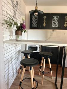 una cocina con taburetes y armarios en blanco y negro en Breza Vacation Home 