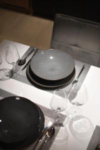 una mesa con platos negros y copas de vino. en K&P - Zadar Luxurious Retreat - BRAND NEW !! en Zadar