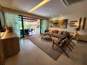 a living room with a couch and a table at Casa Luxo com piscina privativa próximo a Igrejinha - Com colaboradora e enxoval in Praia dos Carneiros