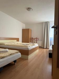 - une chambre avec 2 lits et du parquet dans l'établissement Apartmány Telgárt, à Telgárt