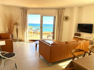 Charming apartment in La Fosca Beach في بالاموس: غرفة معيشة مع أريكة وإطلالة على المحيط