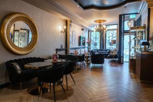 a room with tables and chairs and a mirror at Hotel 83 in Amsterdam