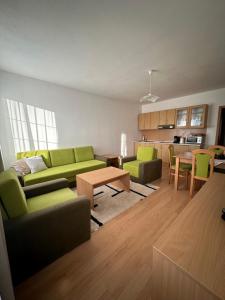 a living room with green couches and a table at Apartmány Telgárt in Telgárt