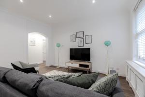 sala de estar con sofá y TV en Luxury Apartments - Fitzrovia en Londres