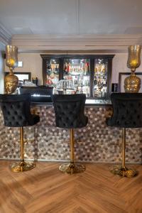 - un bar avec deux tabourets de bar dans une pièce dans l'établissement Hotel 83, à Amsterdam