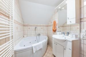 a white bathroom with a tub and a sink at Apartment Eli in Kranjska Gora +16 photos