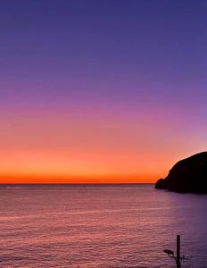 un tramonto sull'oceano con una croce nell'acqua di Casa Bianca A S'Angelo a Ischia