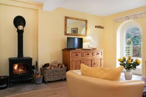 a living room with a fireplace and a couch at Woodcutter's Cottage - Peaceful Country Retreat! 