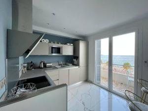 ニースにあるBeach front, Superbe appartement pour 4 personnesの白いキッチン(海の景色を望む)