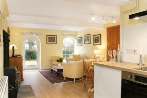 een keuken en een woonkamer met een tafel en een bank bij Woodcutter's Cottage - Peaceful Country Retreat! 