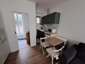 een woonkamer met een keuken, een tafel en een bank bij Appartement Vichy Centre-ville Proche Cure Thermale in Vichy