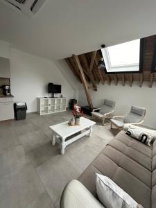 ein Wohnzimmer mit einem Sofa und einem Tisch in der Unterkunft Gîte du Fenil in Lobbes