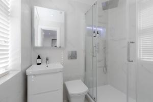 ein weißes Bad mit einem WC und einer Dusche in der Unterkunft Luxury Apartments - Fitzrovia in London