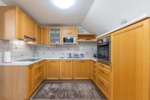 uma cozinha com armários de madeira e um lavatório em Apartment Eli em Kranjska Gora