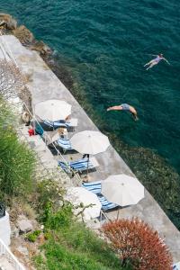 um grupo de guarda-chuvas e pessoas nadando na água em Miramare Sea Resort & Spa em Ischia