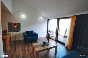 a living room with a blue chair and a table at Villa Stefina in Kotor