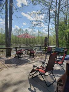 a patio with a table and chairs and an umbrella at Happy Bottom Riverfront Cabin, Petersburg,WV in Rig