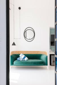a green couch in a white room with a mirror at Miramare Sea Resort & Spa in Ischia