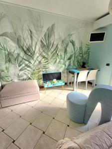 una sala de estar con un mural de hojas en la pared en Maryhouse en Venegono Superiore