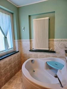 y baño con bañera y radiador. en Maryhouse en Venegono Superiore