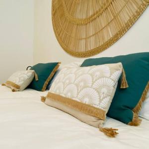 a bed with green and white pillows on it at AH-10 - Luxury 3 BR Beach Apartment in typical island village by Althea in Pointe aux Piments