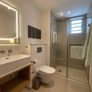 a bathroom with a sink and a toilet and a shower at AH-10 - Luxury 3 BR Beach Apartment in typical island village by Althea in Pointe aux Piments