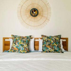 a bedroom with a bed with pillows and a mirror at AH-10 - Luxury 3 BR Beach Apartment in typical island village by Althea in Pointe aux Piments