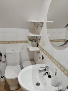 y baño con aseo, lavabo y espejo. en CASA BOURELA, en Cangas de Morrazo