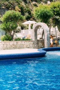 a woman in a bikini jumping into a swimming pool at Miramare Sea Resort & Spa in Ischia