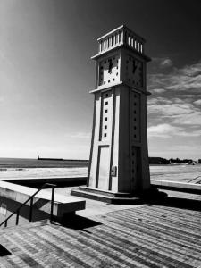 una torre del reloj en un muelle junto a la playa en Fleur Marine - Bienvenue, en Les Sables-dʼOlonne