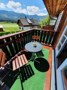 a patio with a table and chairs on a balcony at Haus Kampl - Appartement Ödensee in Obersdorf