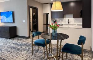 a kitchen with a table with blue chairs and a counter at SpringHill Suites by Marriott Chicago Chinatown in Chicago