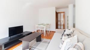 uma sala de estar com um sofá e uma televisão em Fabulous Matosinhos Apartment by Unique Hosts em Senhora da Hora