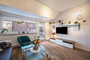 a living room with a tv and a glass table at Haus Heidorn in Sittensen