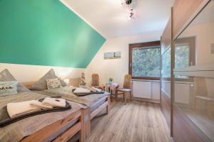 Un dormitorio con una cama grande y una pared verde en Haus Heidorn, en Sittensen