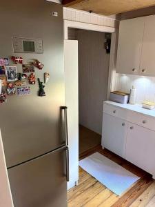 a kitchen with a stainless steel refrigerator with magnets at Biały domek nad jeziorem Selment in Buczki +10 photos