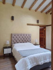 a bedroom with a large bed and two night stands at Cute House Surrounded by Nature in Yucay
