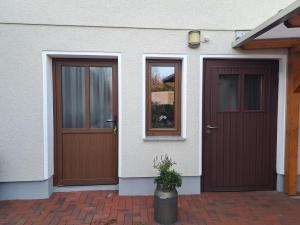 a house with two doors and a potted plant at Ferienwohnung am Weißgerbermuseum in Doberlug-Kirchhain