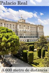 Un gran edificio blanco con árboles delante. en AbraCadabra Suites, en Madrid